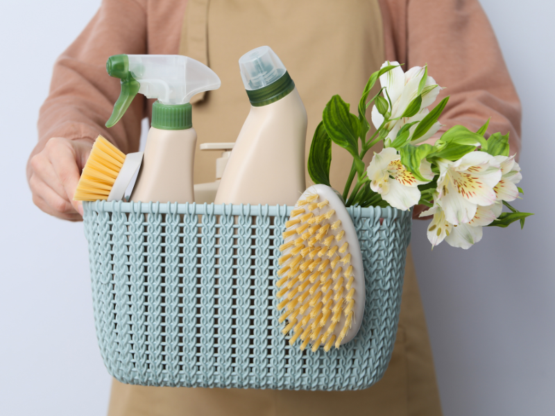 person holding a basket of cleaning products