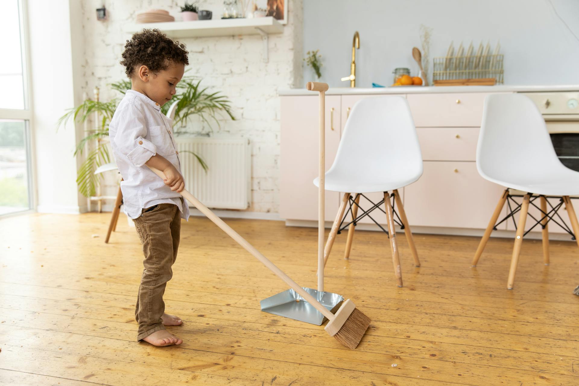 little boy sweeping with a broom