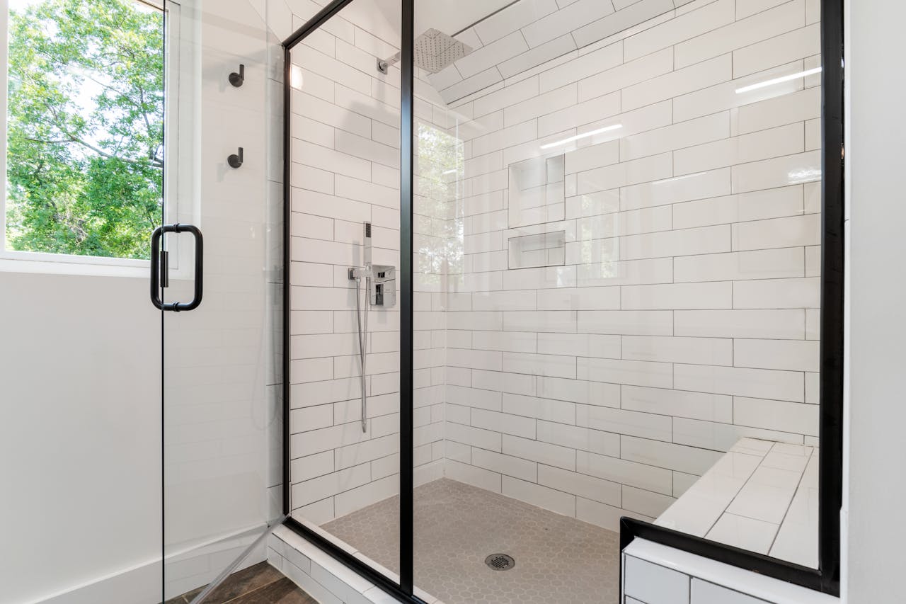 white subway tile shower with black trim
