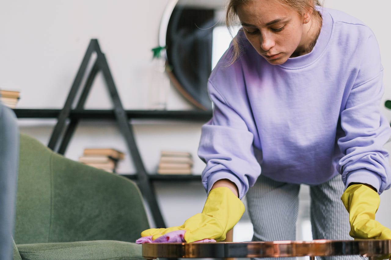 woman in lavendar with yellow gloves wiping table in Palm Harbor, Florida