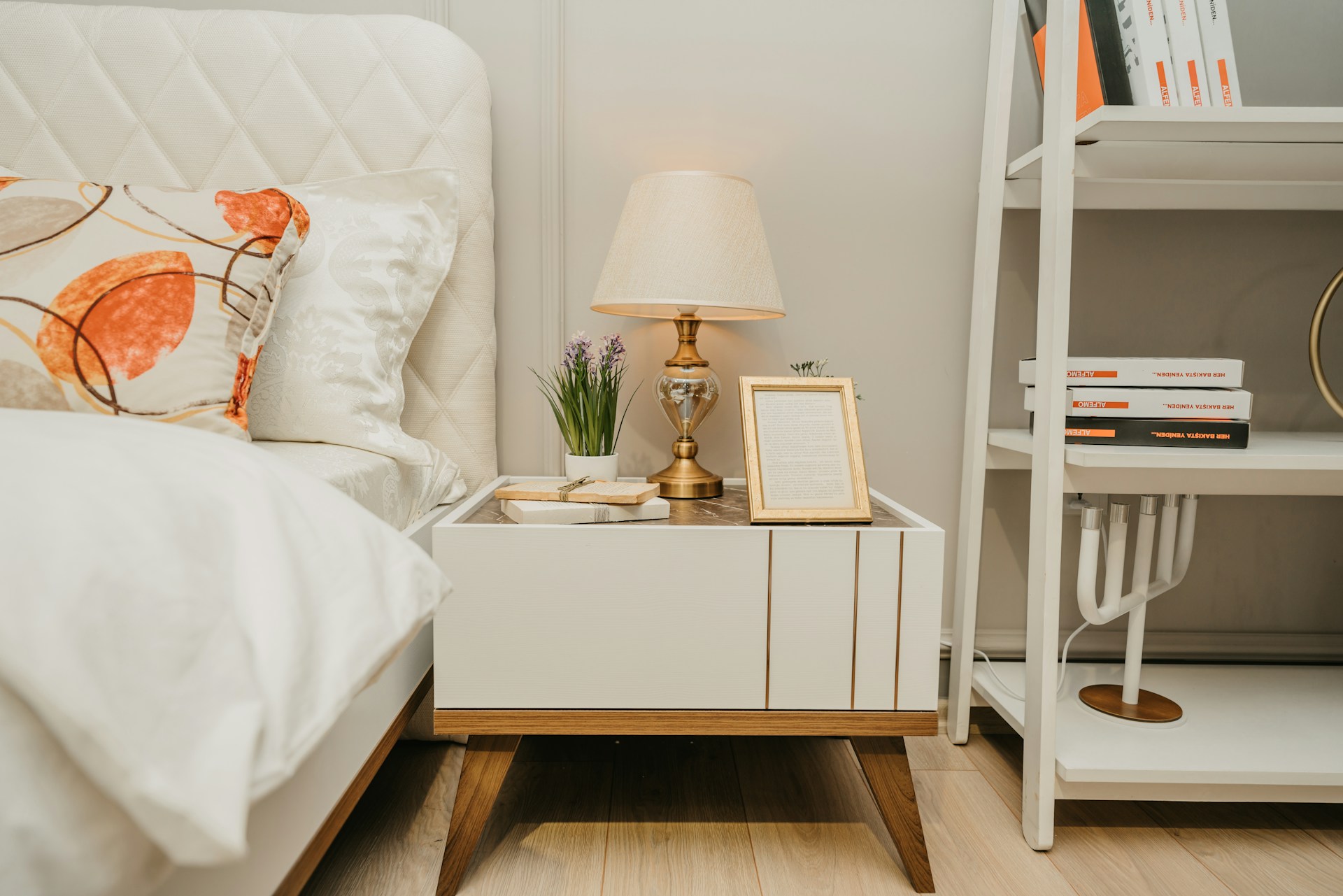 table lamp and nightstand in guest bedroom with white linens, bright and airy feel