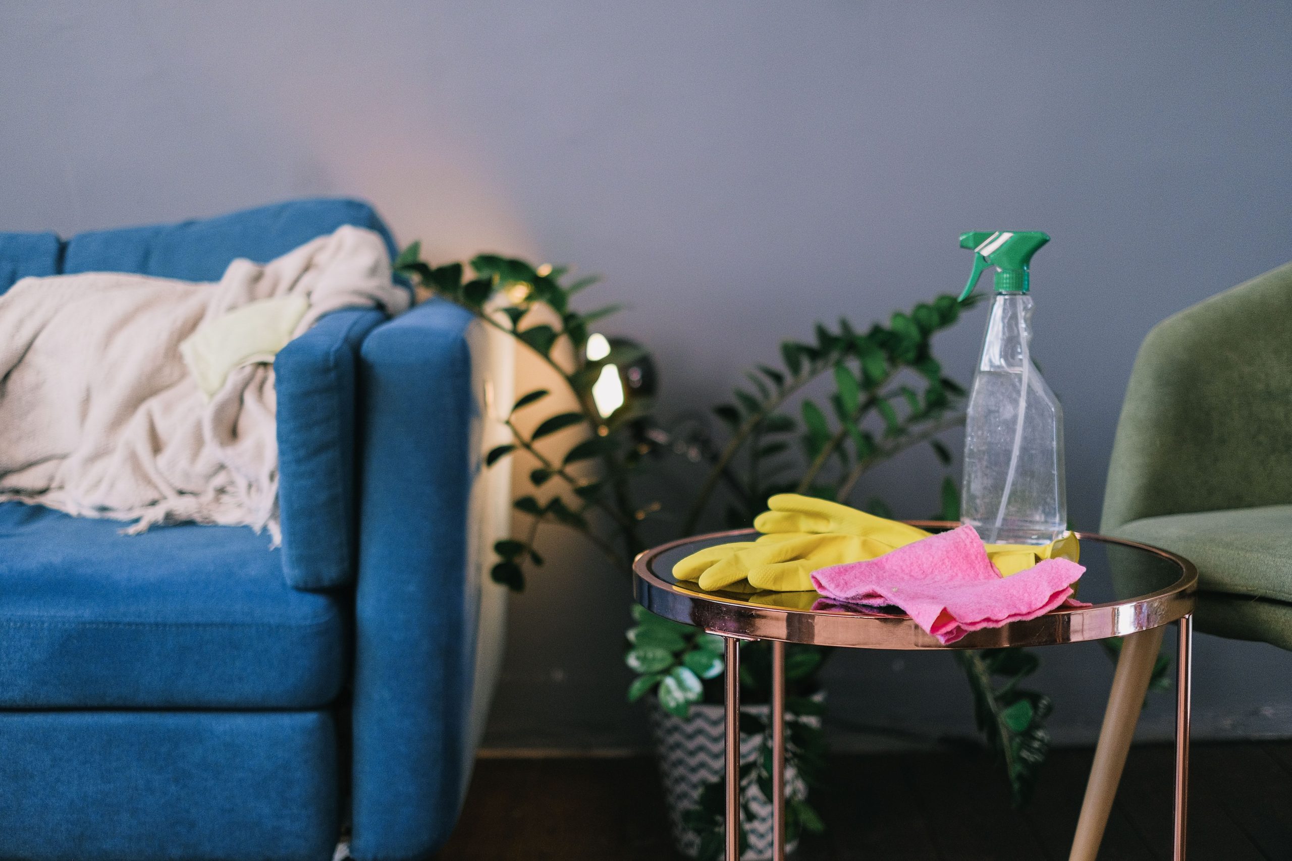 a living room with a cleaning supplies on a side table. Maid Impressions Cleaning