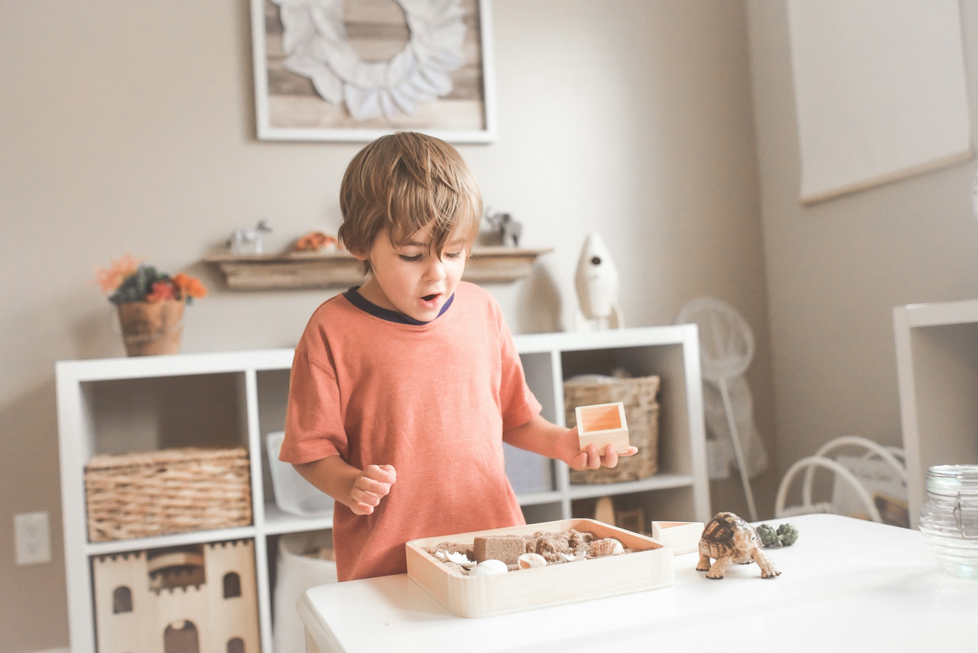 small boy playing with blocks in room