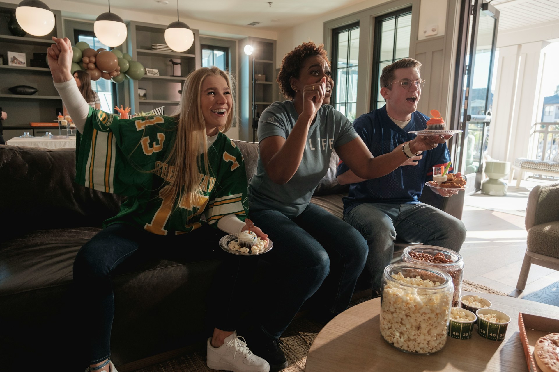 people cheering on their team for game day at home