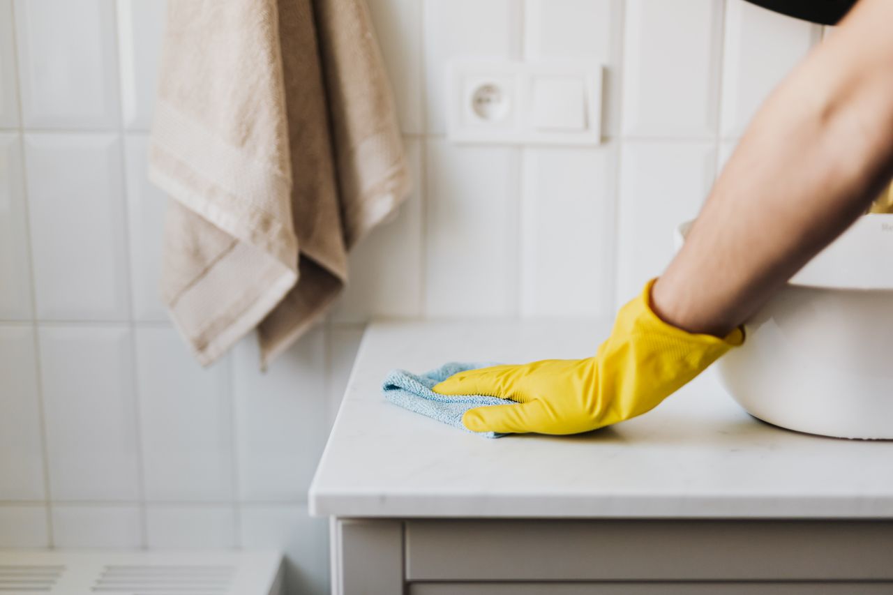 woman in yellow gloves cleaning bathroom